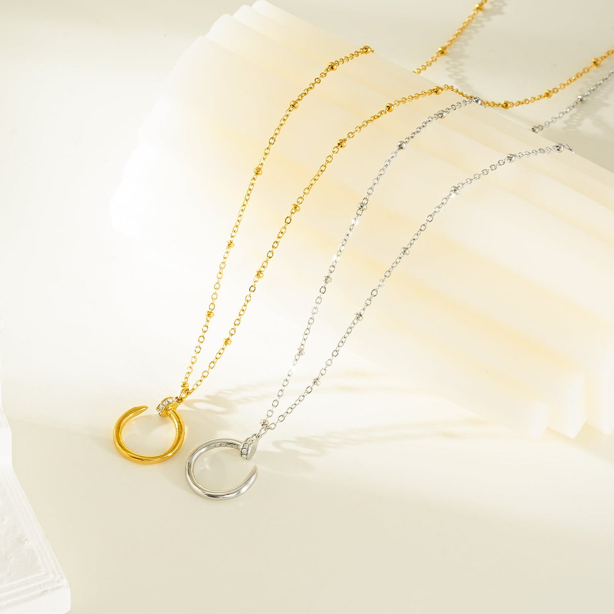 CSENGE Gold Necklace: Zirconia Embedded Circular Nail Pendant on a Satellite Beaded Chain