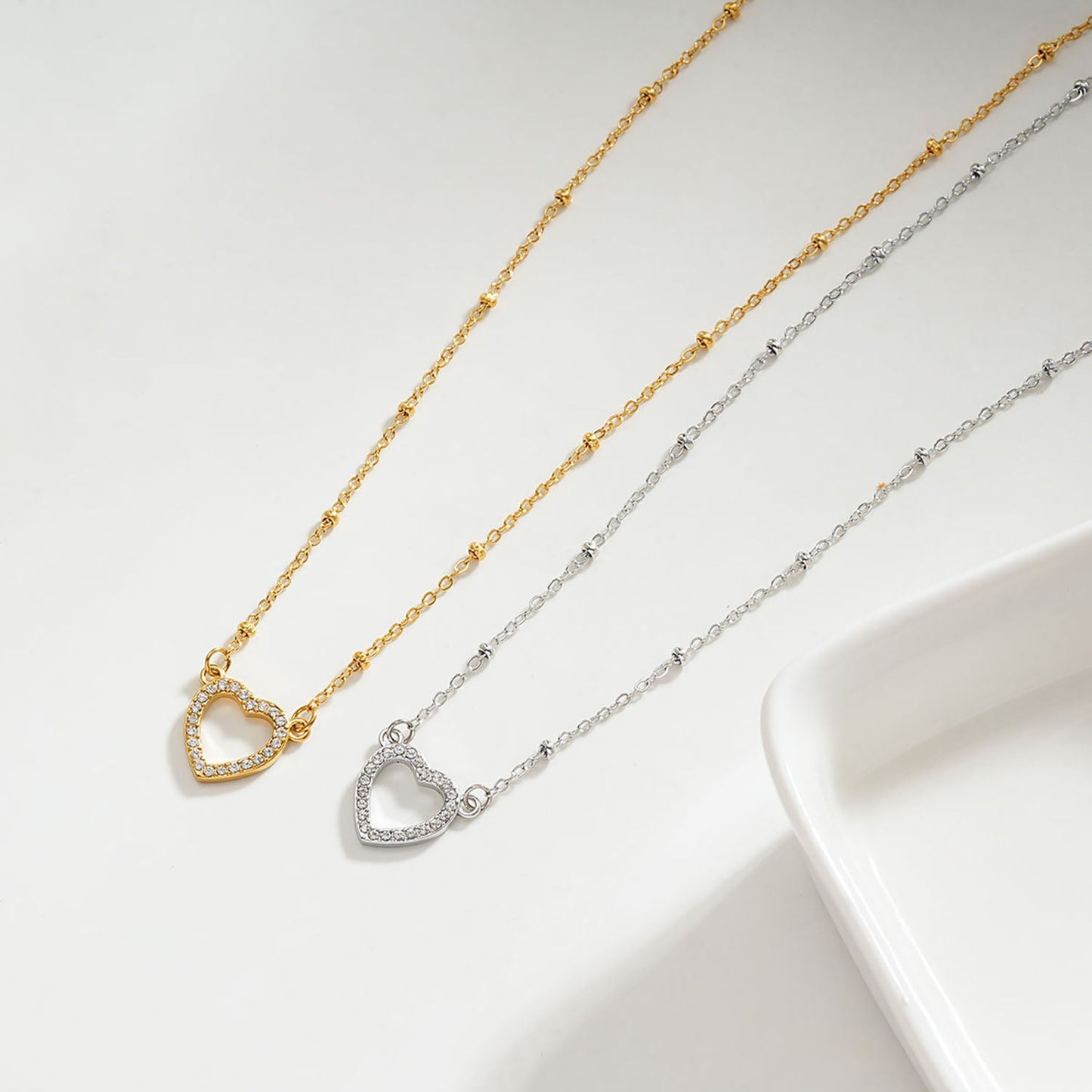 Style CHERISH Or : Chaîne perlée soutenant un élégant pendentif cœur pavé