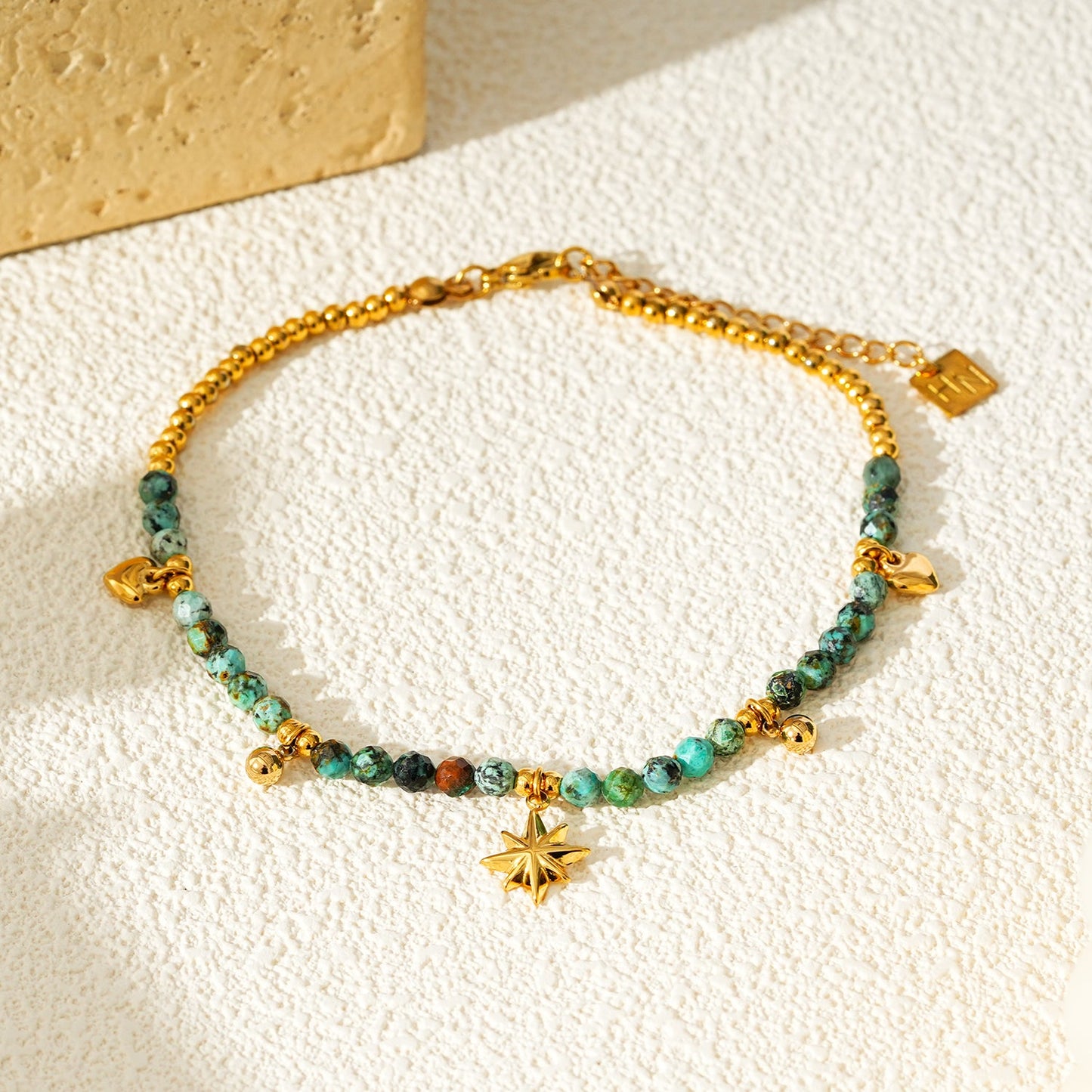 KAVYA LG : Cheville chaîne en perles et breloques dorées avec pierres turquoises bleues
