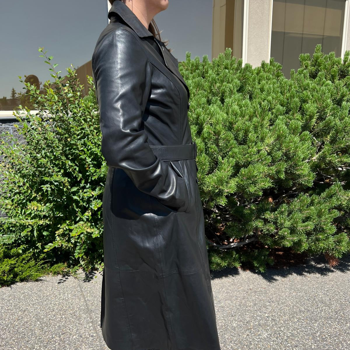 Trench-coat classique en cuir pour femme. Double boutonnage avec ceinture ajustable.