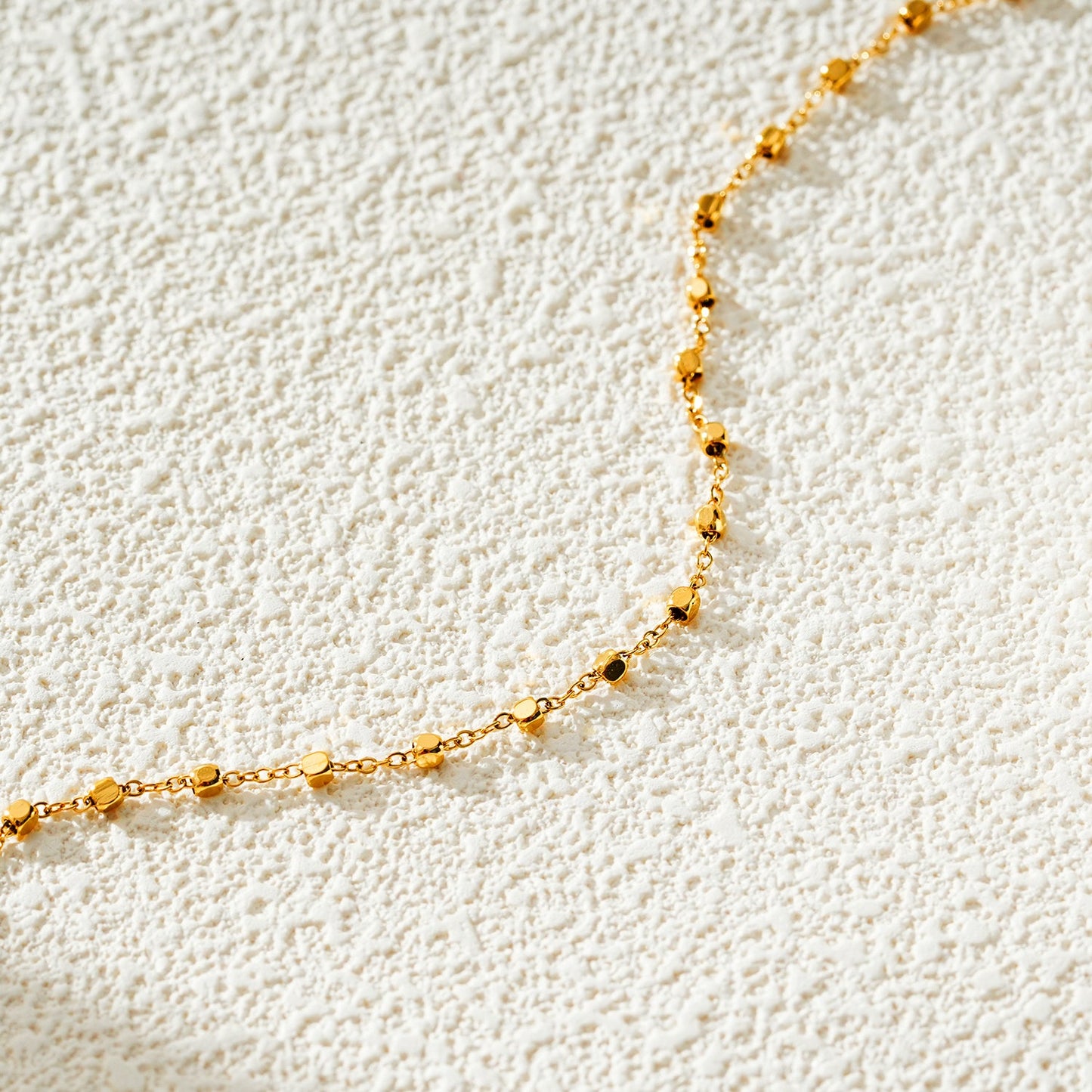 DEMELZA LG : Cheville contemporaine dorée avec perles carrées délicates