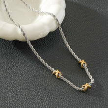 COSMINA Métaux Mixtes : Collier chaîne torsadée en argent avec trois mini breloques croisées dorées