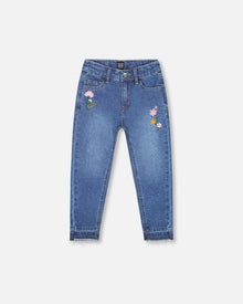 Jean bleu en denim avec ourlets effilochés et broderies florales