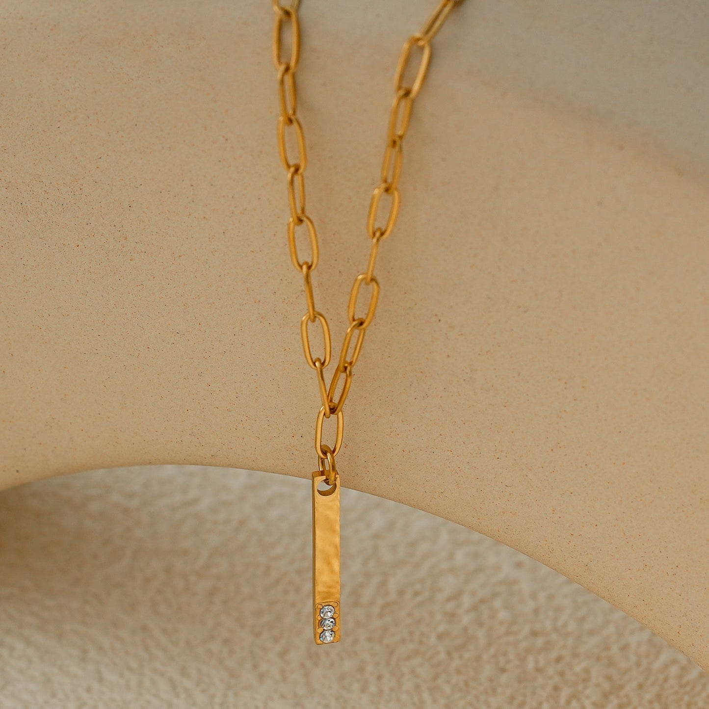 Style KORATIA : Collier Minimaliste avec Chaîne Trombone et Pendentif Barre Ornée de Zirconium Doré