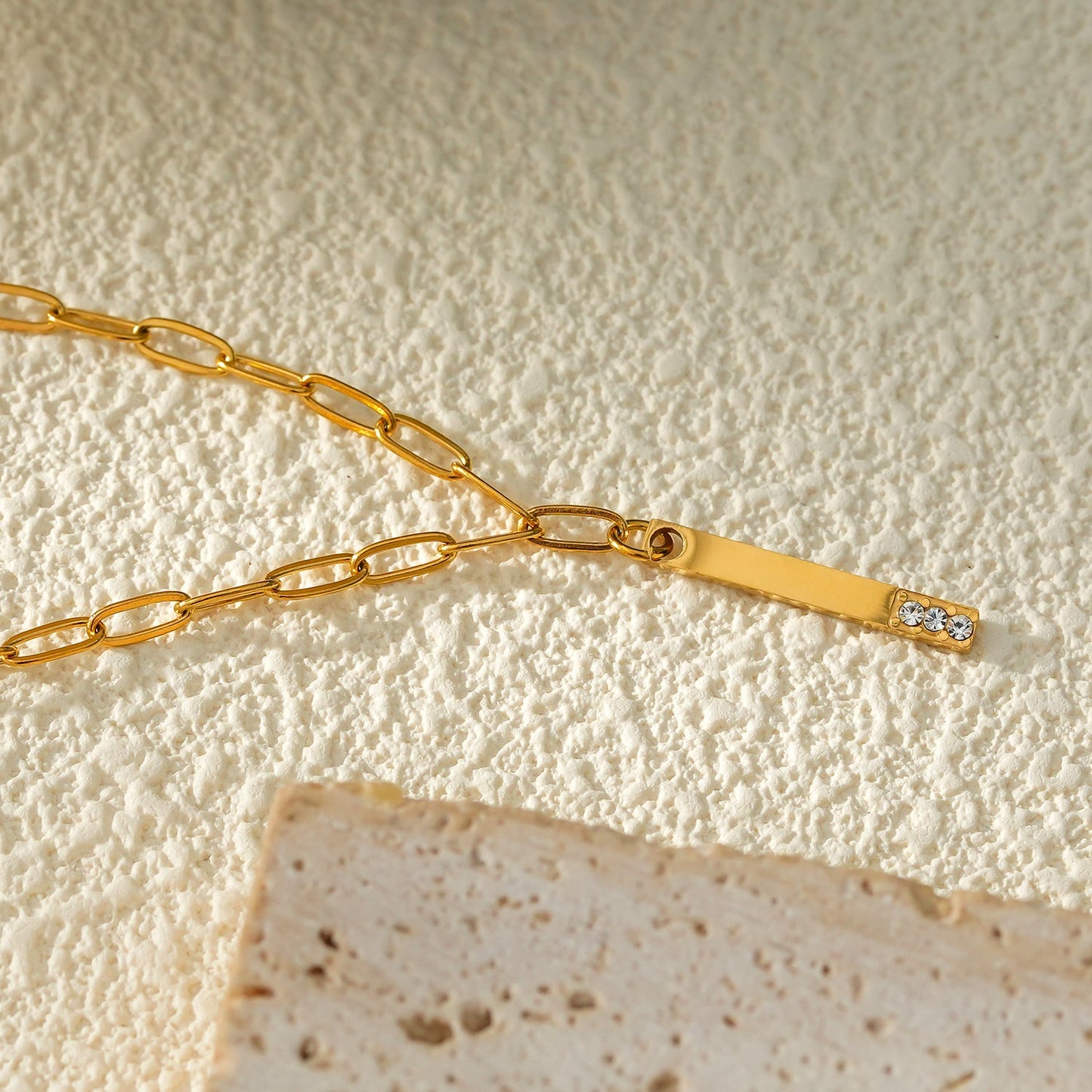 Style KORATIA : Collier Minimaliste avec Chaîne Trombone et Pendentif Barre Ornée de Zirconium Doré