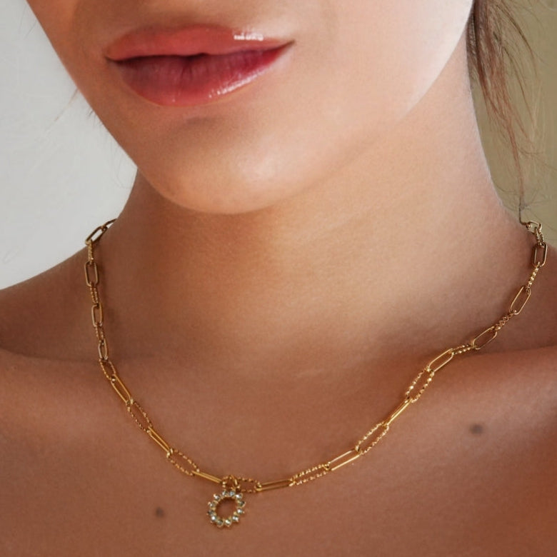 FRETTA : Collier à Pendentif Étoile Rayonnante en Zirconium avec Chaîne Trombone en Plaqué Or.
