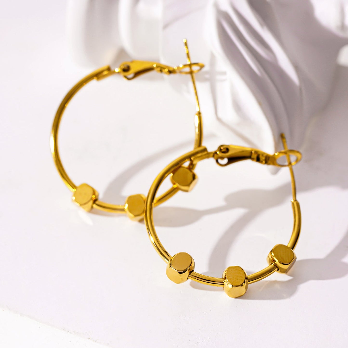 MASUYO: Boucles d'oreilles créoles arrondies d'avant-garde, ornées d'un trio de perles carrées.