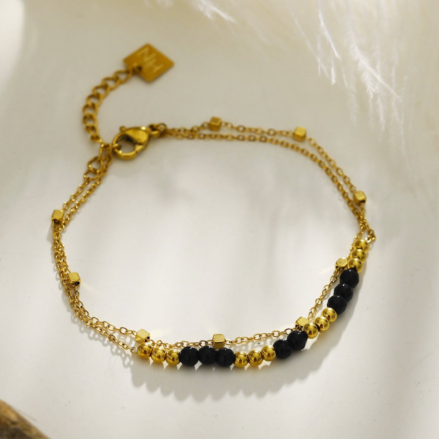 HILDA : Bracelet deux-en-un perles carrées et perles rondes en noir et or.