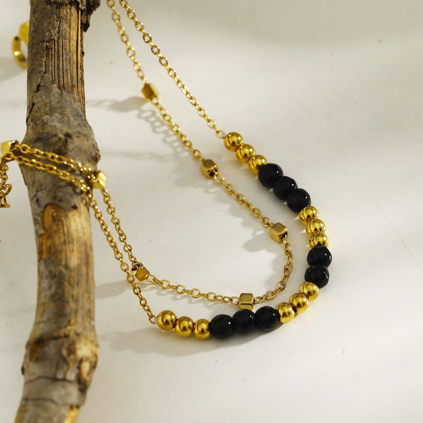 HILDA : Bracelet deux-en-un perles carrées et perles rondes en noir et or.