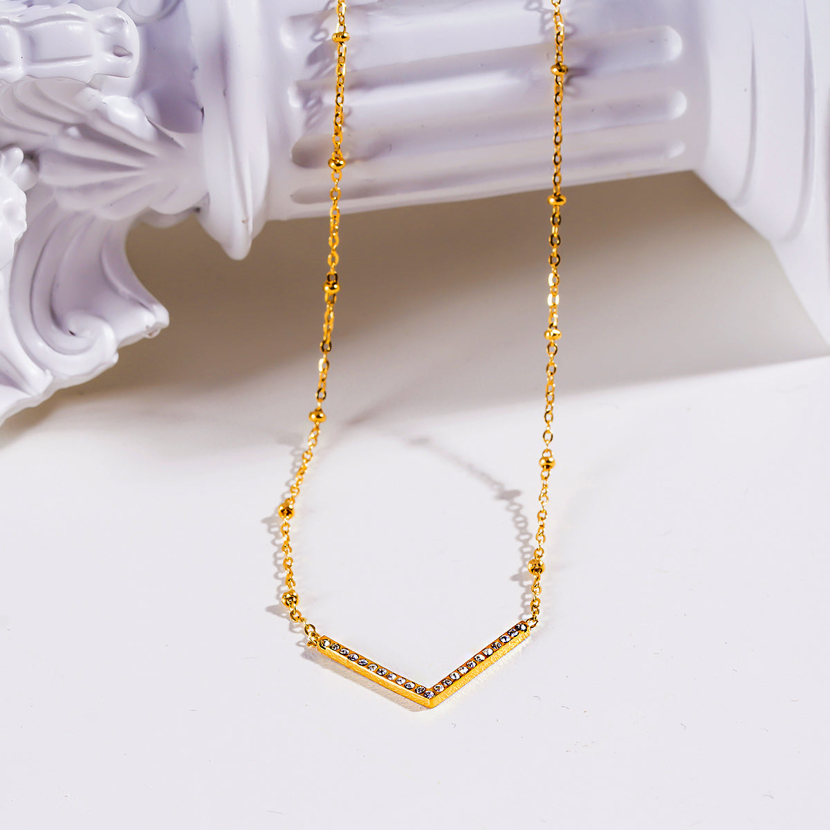 SANITA : Collier fin à maillons perlés orné d'un pendentif en forme de « V » incrusté de zircons