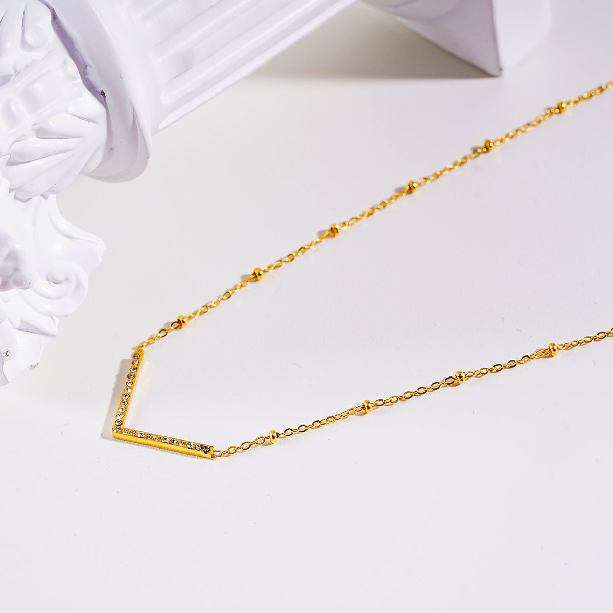 SANITA : Collier fin à maillons perlés orné d'un pendentif en forme de « V » incrusté de zircons