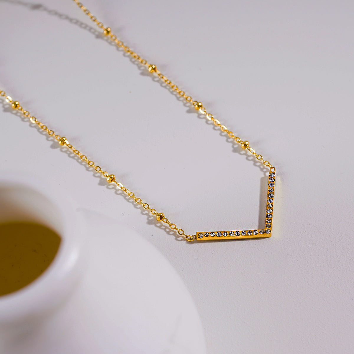 SANITA : Collier fin à maillons perlés orné d'un pendentif en forme de « V » incrusté de zircons