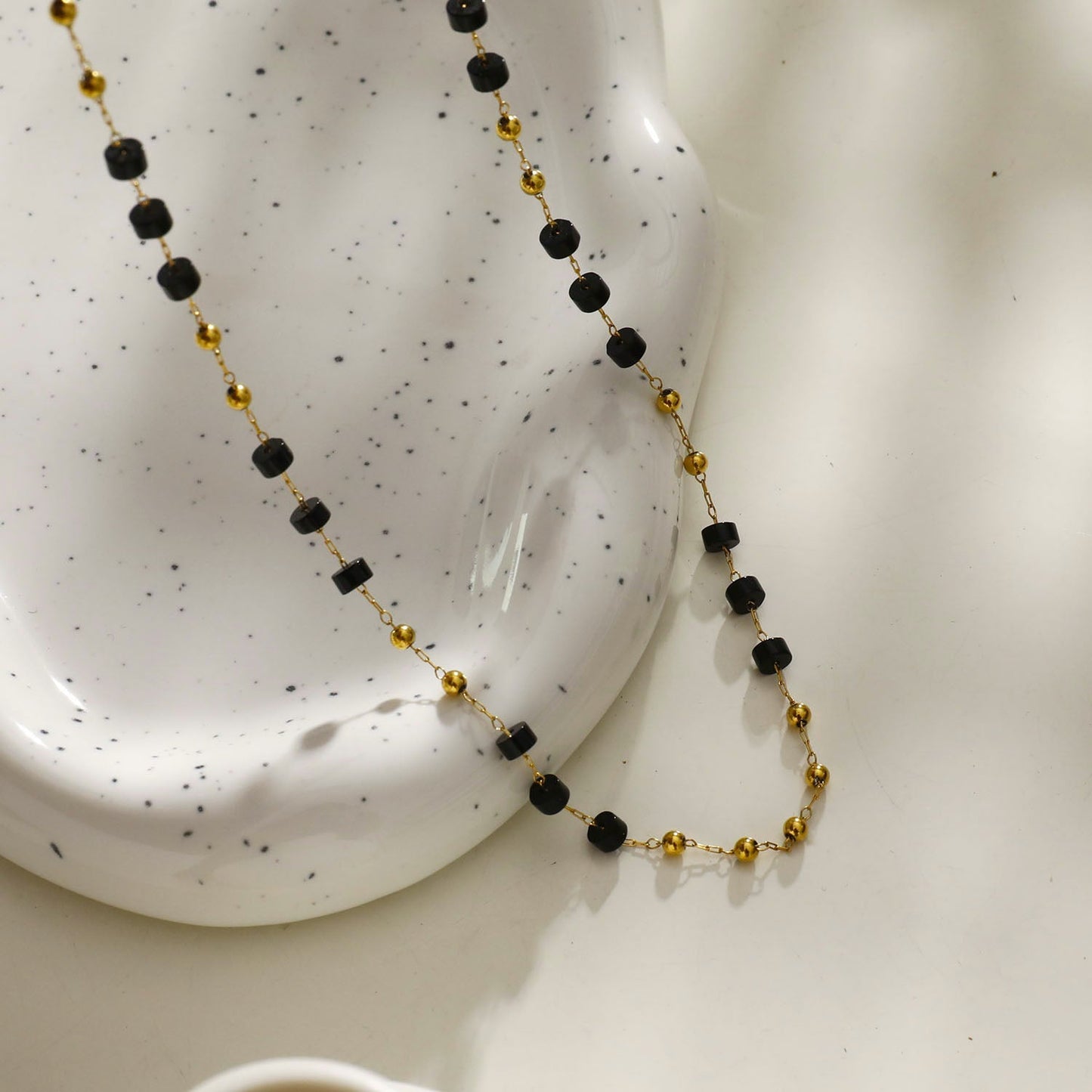 SANTA CRUZ Noir : Collier ras du cou en perles d'onyx noir et or