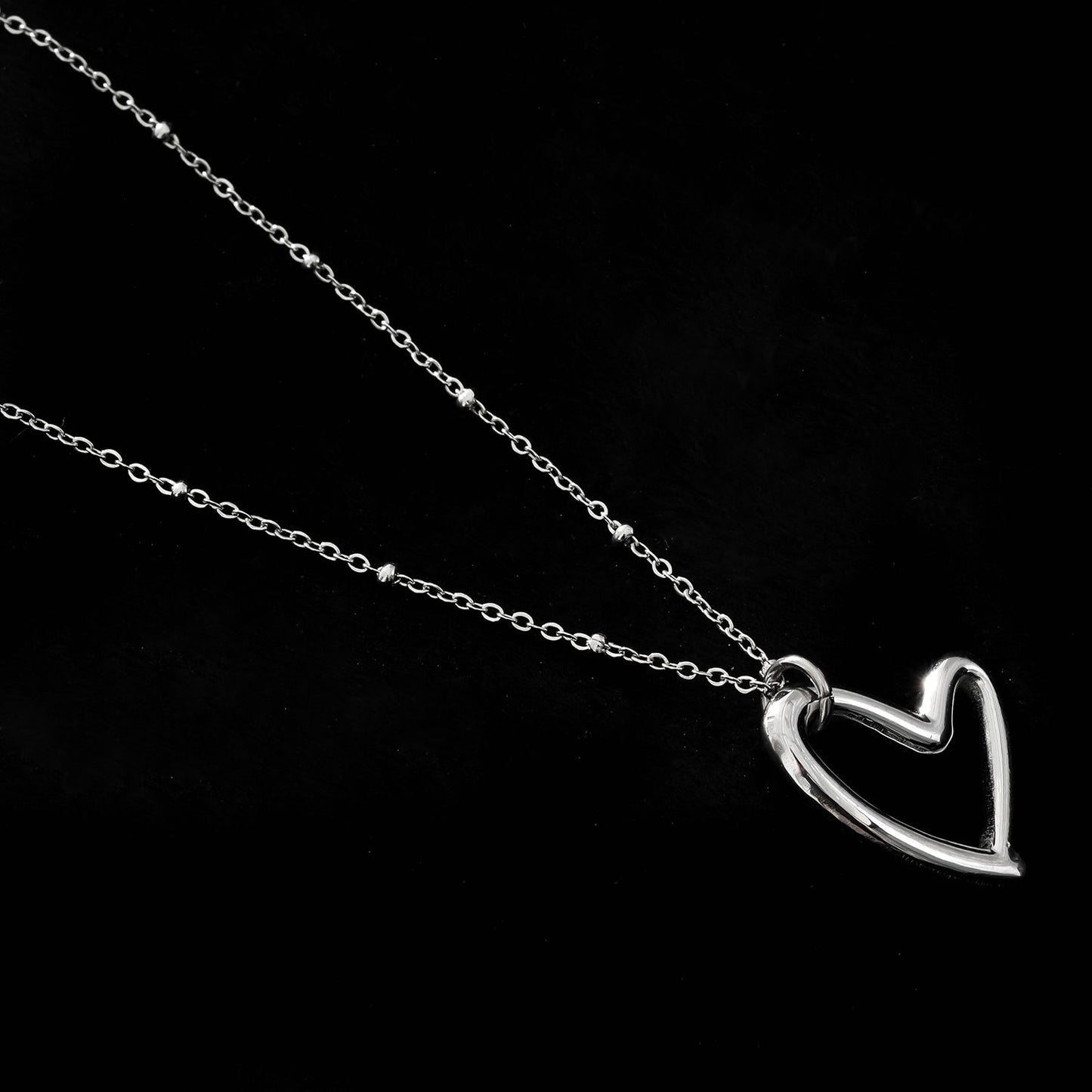 SMITTEN Argent (Or Blanc) : Une chaîne perlée délicate retenant un pendentif abstrait en forme de cœur