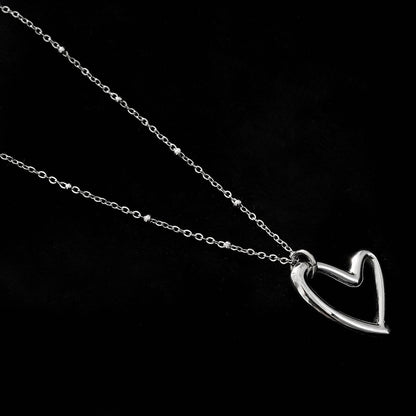 SMITTEN Argent (Or Blanc) : Une chaîne perlée délicate retenant un pendentif abstrait en forme de cœur
