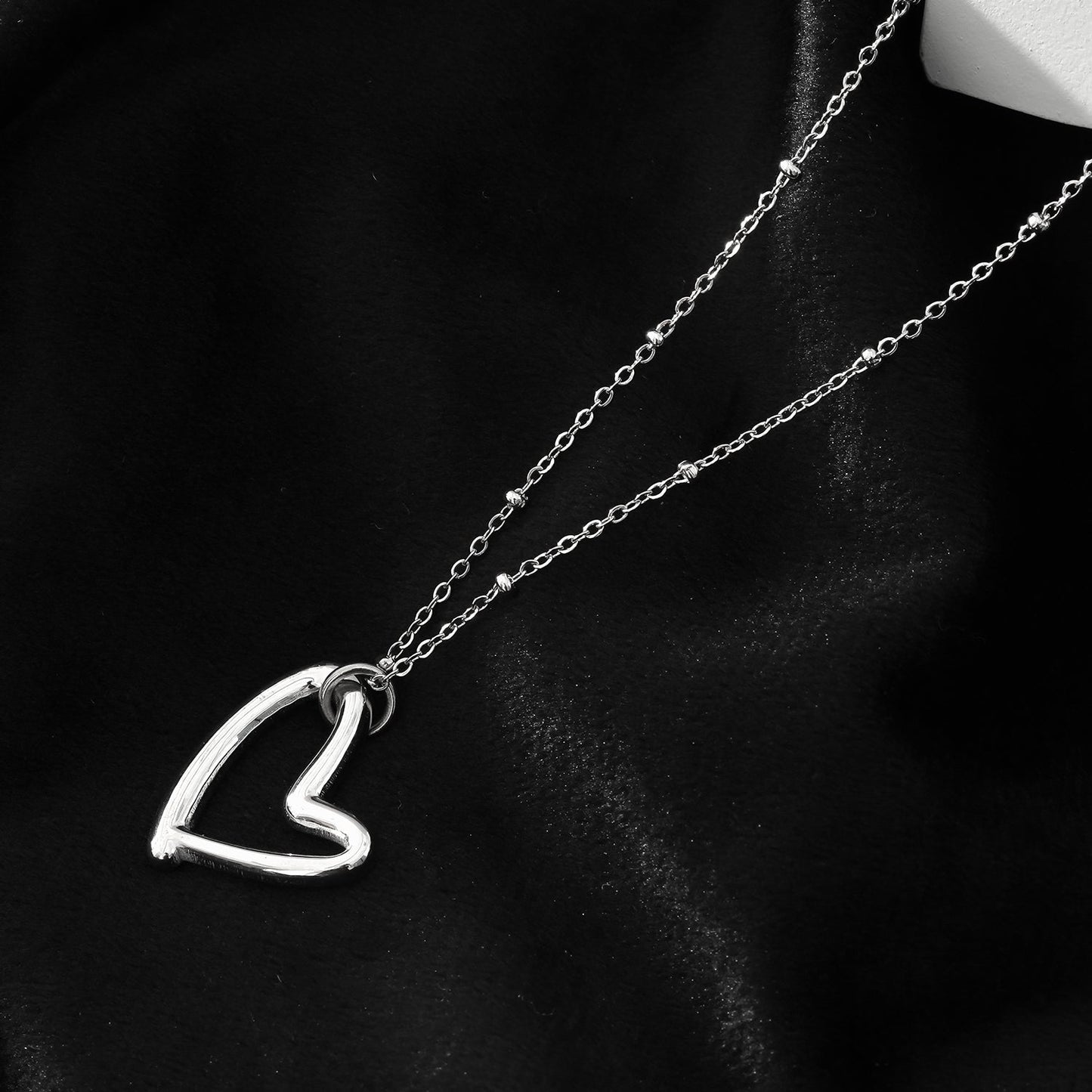 SMITTEN Argent (Or Blanc) : Une chaîne perlée délicate retenant un pendentif abstrait en forme de cœur