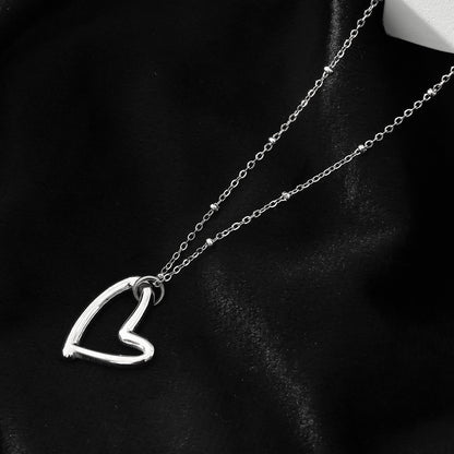 SMITTEN Argent (Or Blanc) : Une chaîne perlée délicate retenant un pendentif abstrait en forme de cœur