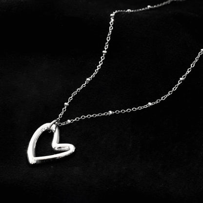 SMITTEN Argent (Or Blanc) : Une chaîne perlée délicate retenant un pendentif abstrait en forme de cœur