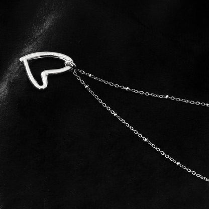 SMITTEN Argent (Or Blanc) : Une chaîne perlée délicate retenant un pendentif abstrait en forme de cœur