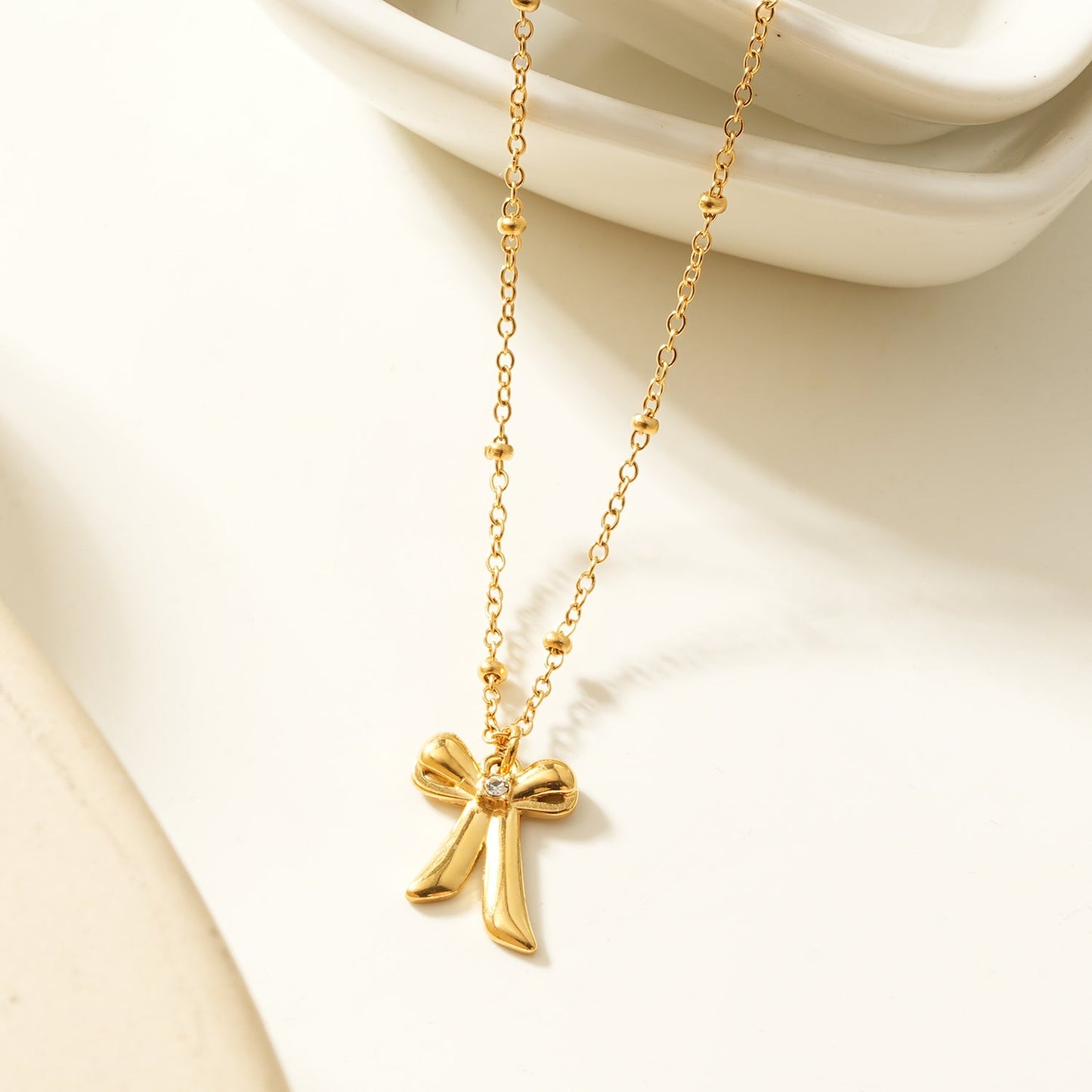 TALIANA Gold : Collier chaîne délicate perlée avec pendentif nœud et zircone solitaire – Bijou élégant pour tous les jours