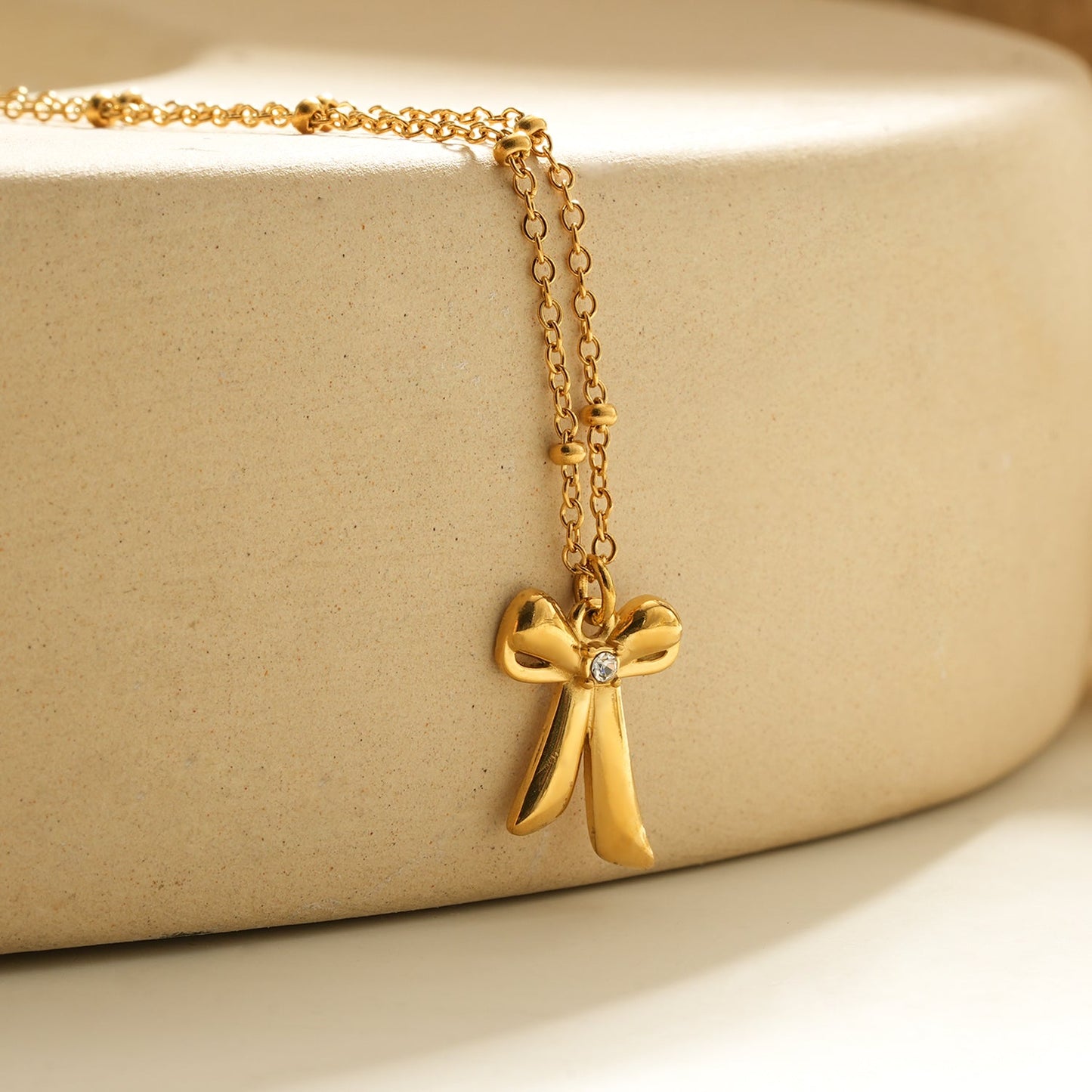TALIANA Gold : Collier chaîne délicate perlée avec pendentif nœud et zircone solitaire – Bijou élégant pour tous les jours