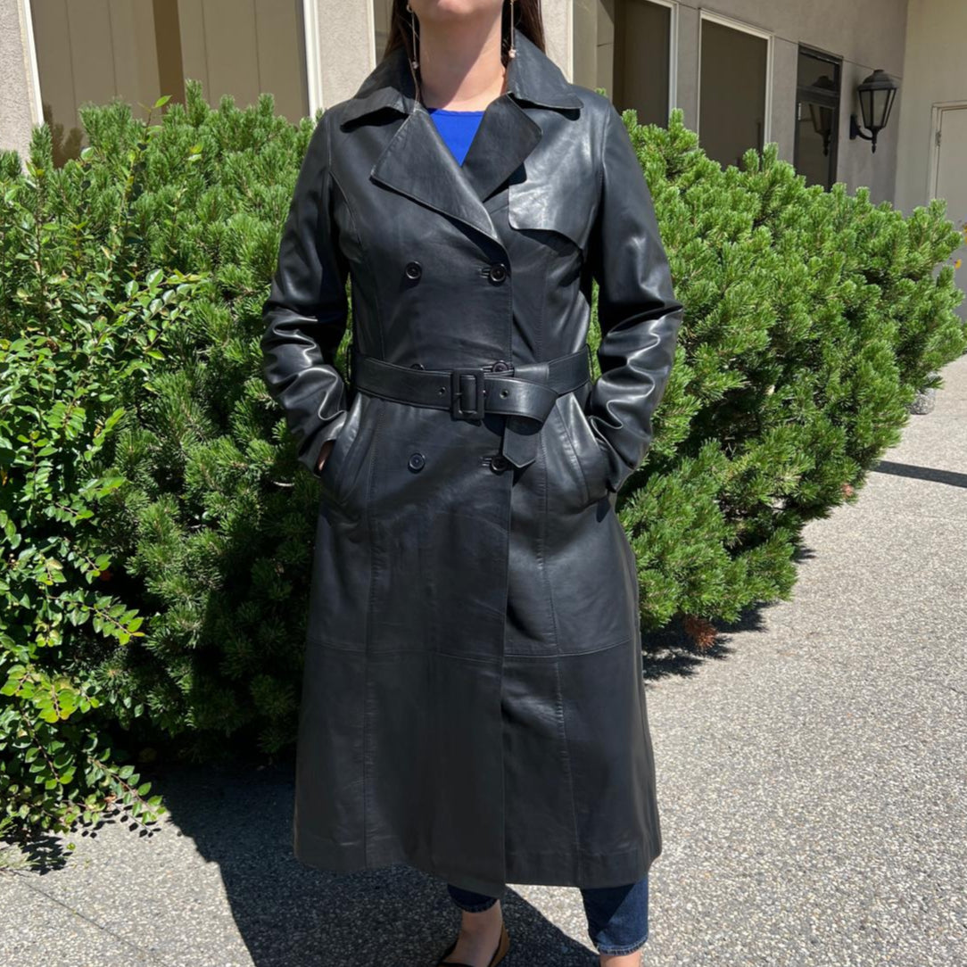 Trench-coat classique en cuir pour femme. Double boutonnage avec ceinture ajustable.