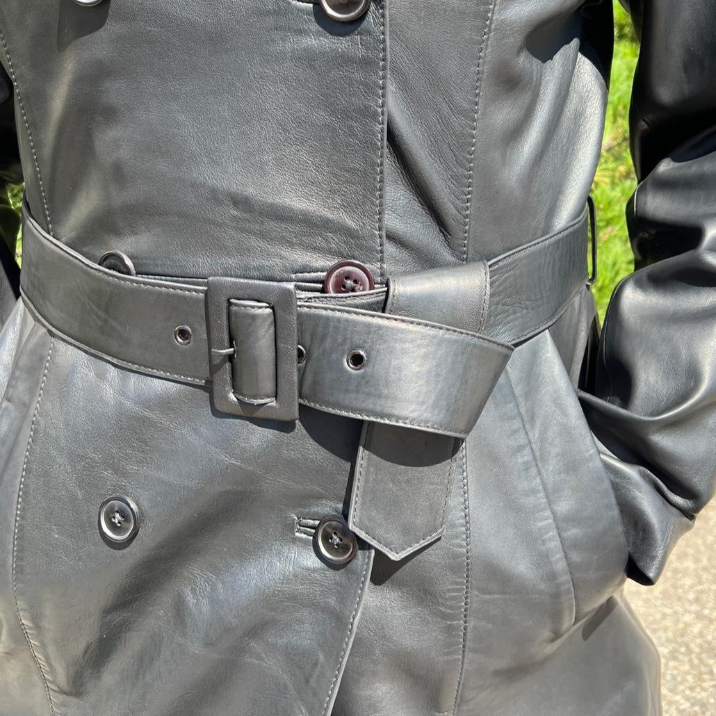 Trench-coat classique en cuir pour femme. Double boutonnage avec ceinture ajustable.