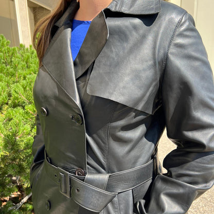 Trench-coat classique en cuir pour femme. Double boutonnage avec ceinture ajustable.