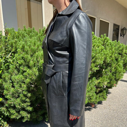 Trench-coat classique en cuir pour femme. Double boutonnage avec ceinture ajustable.