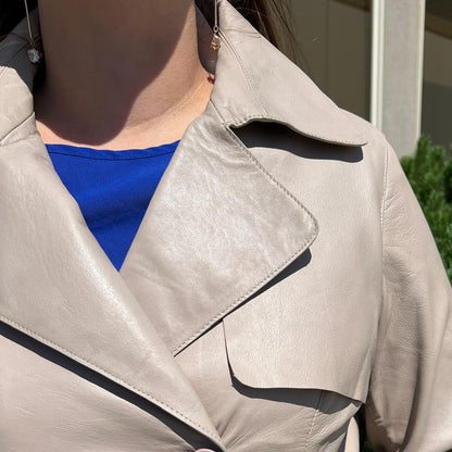 Trench-coat classique en cuir pour femme. Double boutonnage avec ceinture ajustable.