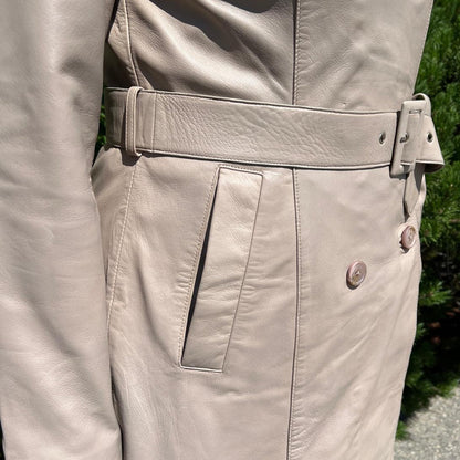 Trench-coat classique en cuir pour femme. Double boutonnage avec ceinture ajustable.