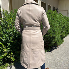 Trench-coat classique en cuir pour femme. Double boutonnage avec ceinture ajustable.