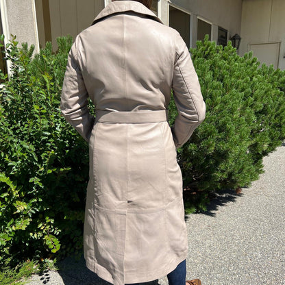 Trench-coat classique en cuir pour femme. Double boutonnage avec ceinture ajustable.
