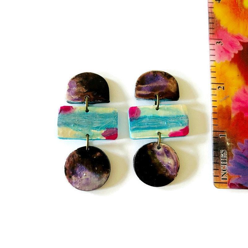 Boucles d'oreilles pendantes originales peintes dans un style abstrait