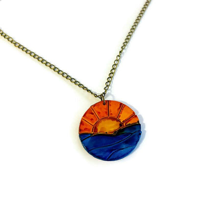Collier pendentif lever de soleil, le soleil se lève sur l'océan