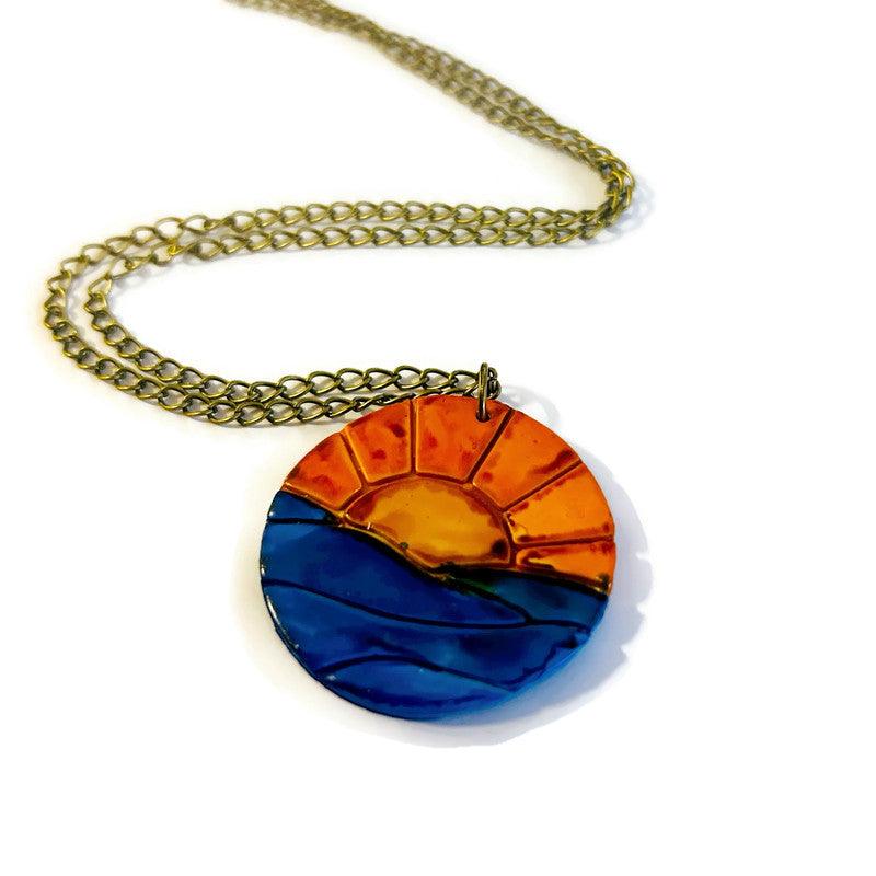 Collier pendentif lever de soleil, le soleil se lève sur l'océan