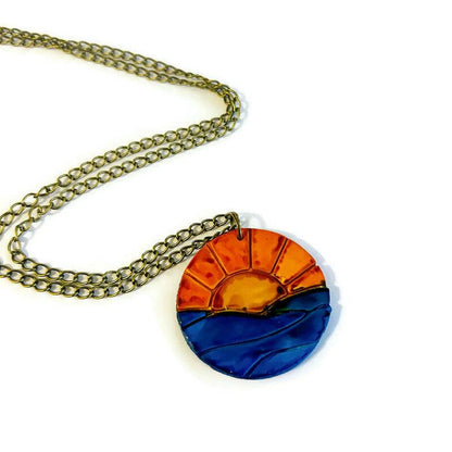 Collier pendentif lever de soleil, le soleil se lève sur l'océan