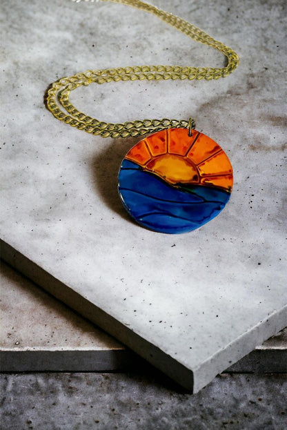Collier pendentif lever de soleil, le soleil se lève sur l'océan